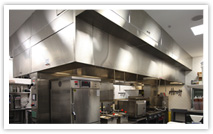 Self-cleaning restaurant hood installation in a full commercial kitchen setting.